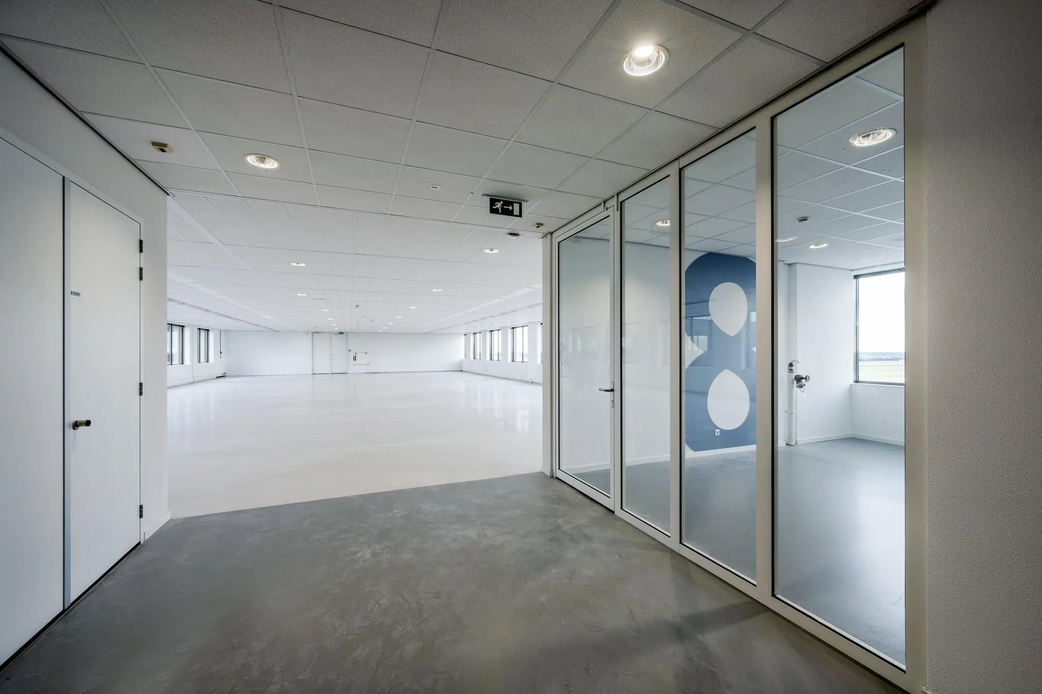 Lichte, moderne kantoorruimte op Rotterdam Airportplein met glazen scheidingswand en uitzicht op de start- en landingsbaan.